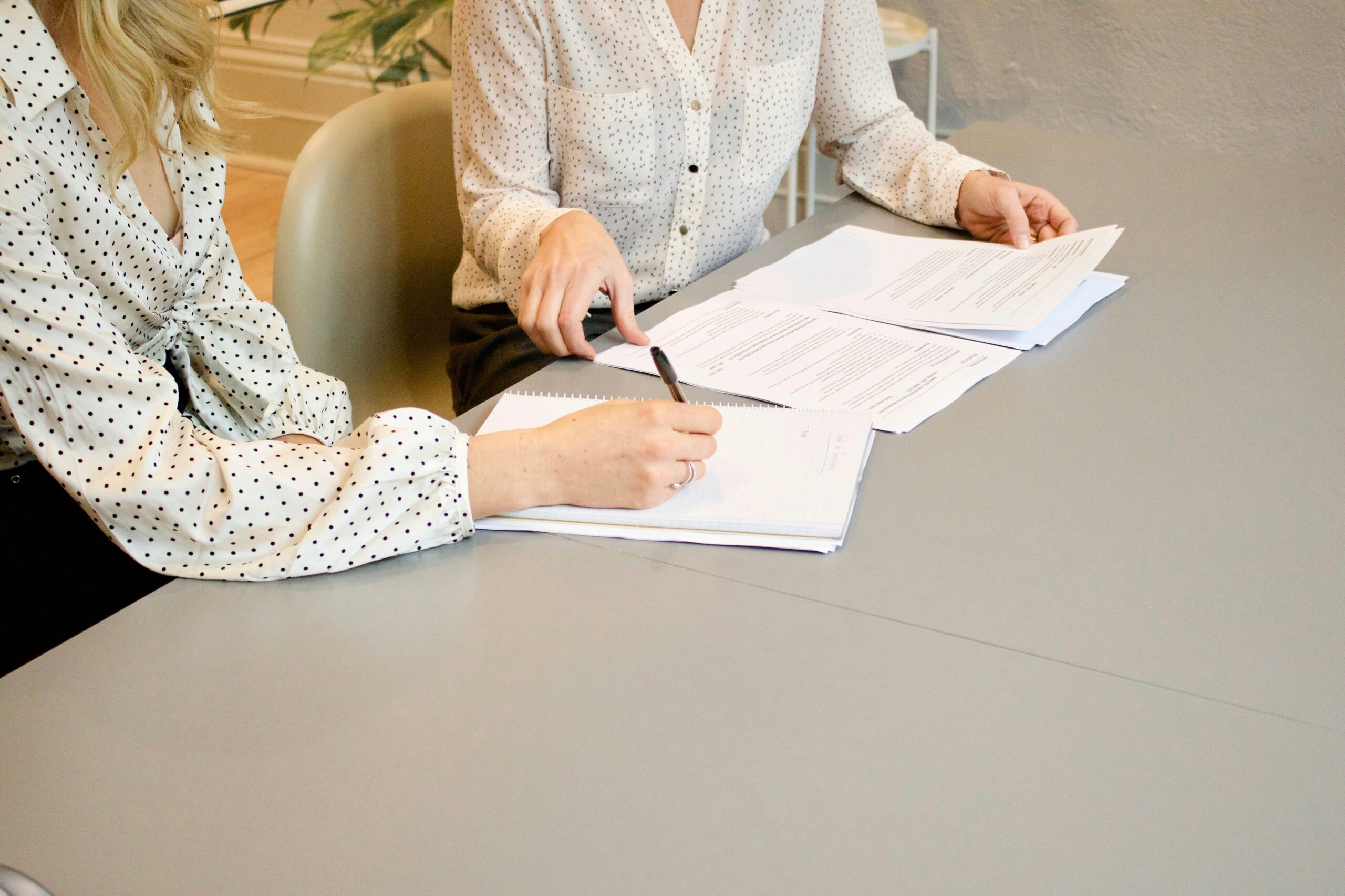 Two people reviewing documents at table.