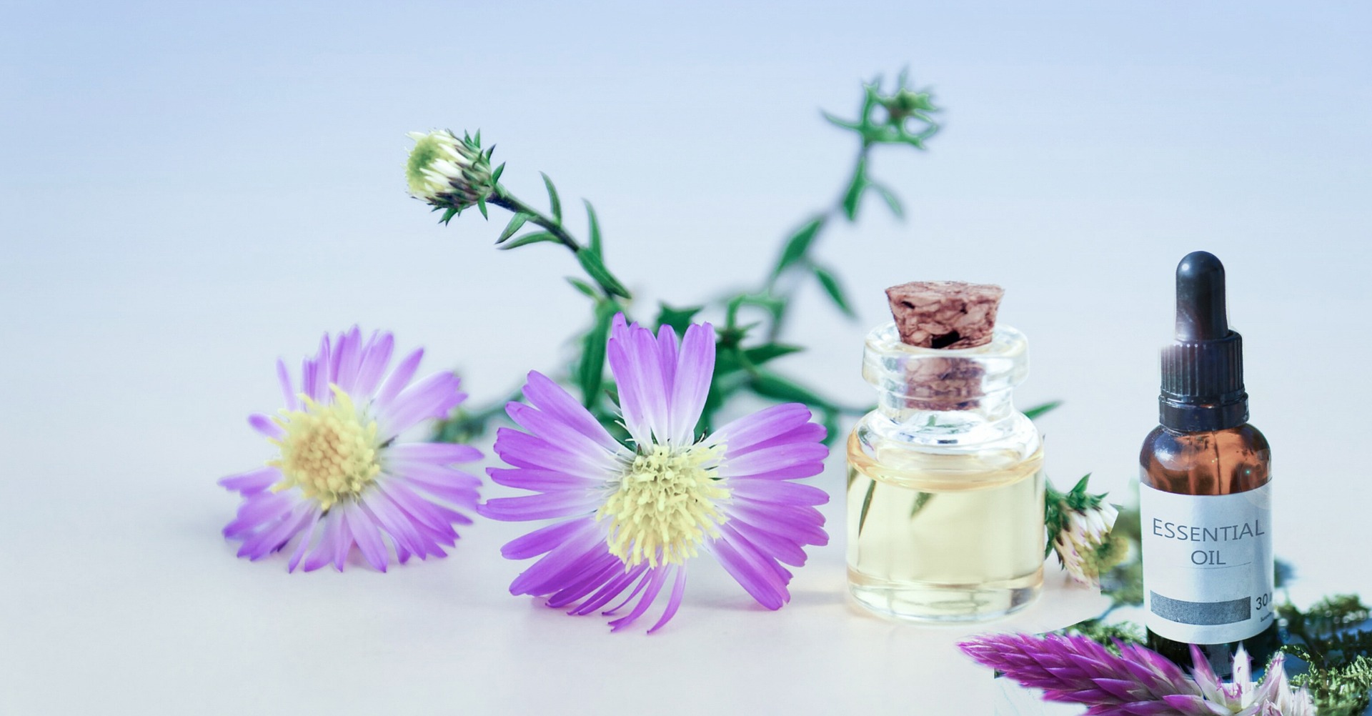 Essential oils and flowers representing holistic therapy and therapy liability insurance protection